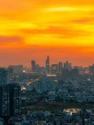 Southeast Asian city skyline under a burning orange sunset